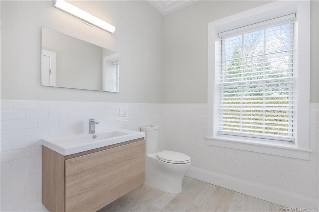 1990 Bronson Road, Unit 8 Fairfield, CT 06824 - Photo 16 of 28 a bathroom with a sink toilet and a mirror