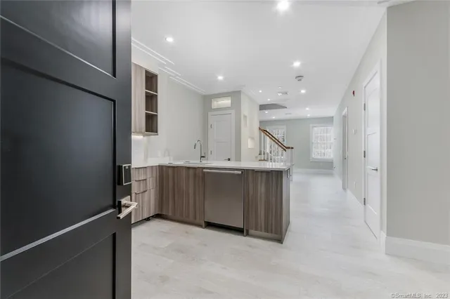 a view of cabinets with kitchen island sink and refrigerator