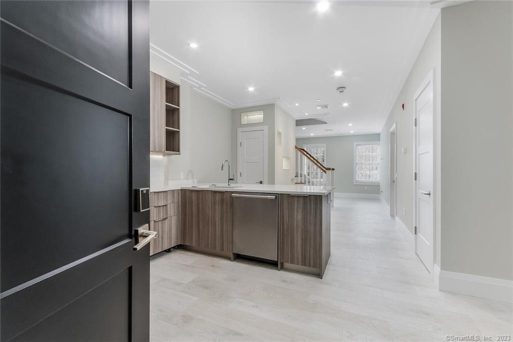 1990 Bronson Road, Unit 8 Fairfield, CT 06824 - Photo 2 of 28 a view of cabinets with kitchen island sink and refrigerator