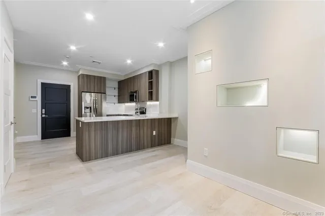 a view of kitchen with kitchen island stainless steel appliances cabinets a sink and a counter top space