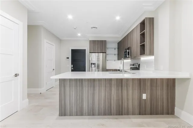 a kitchen with kitchen island a sink stainless steel appliances and cabinets