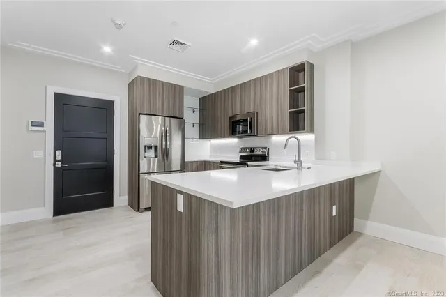 a kitchen with kitchen island a refrigerator sink and microwave