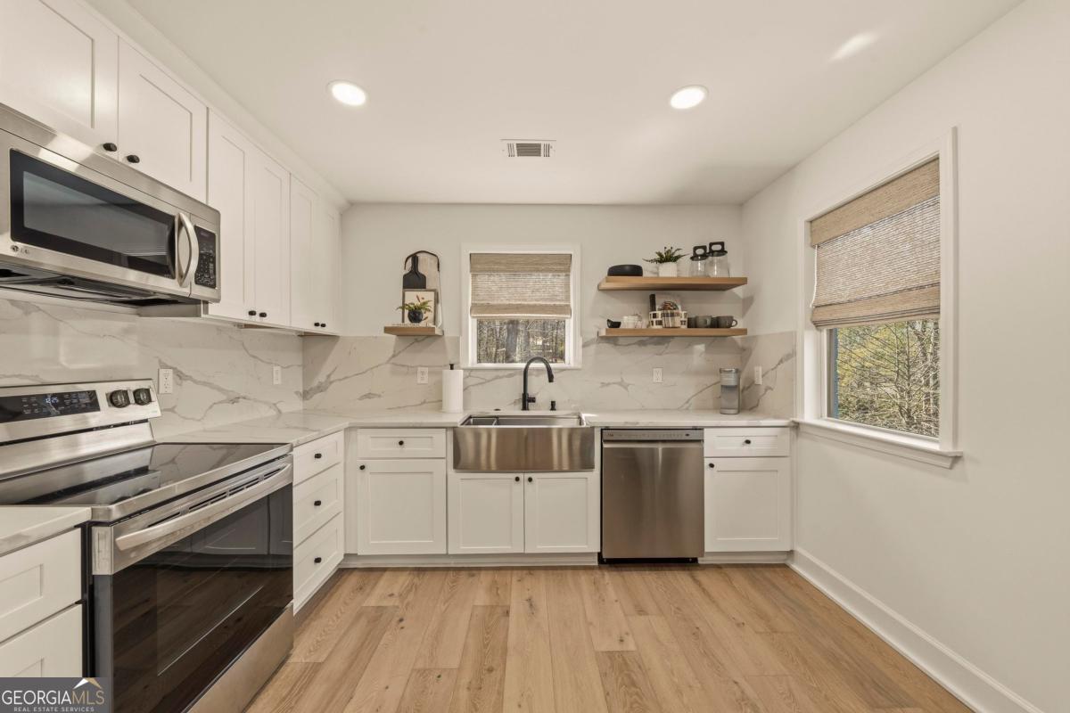 121 Mags Path Eatonton, GA 31024 - Photo 19 of 74 a kitchen with stainless steel appliances a stove a sink and a microwave