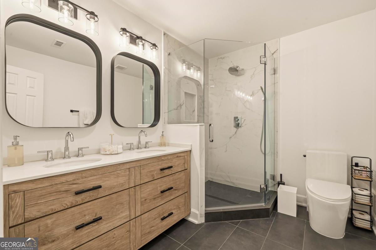 121 Mags Path Eatonton, GA 31024 - Photo 37 of 74 a bathroom with a double vanity sink toilet mirror and shower