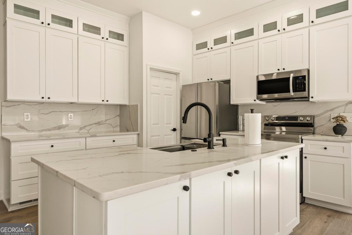 121 Mags Path Eatonton, GA 31024 - Photo 45 of 74 a kitchen with stainless steel appliances granite countertop a sink a stove and cabinets