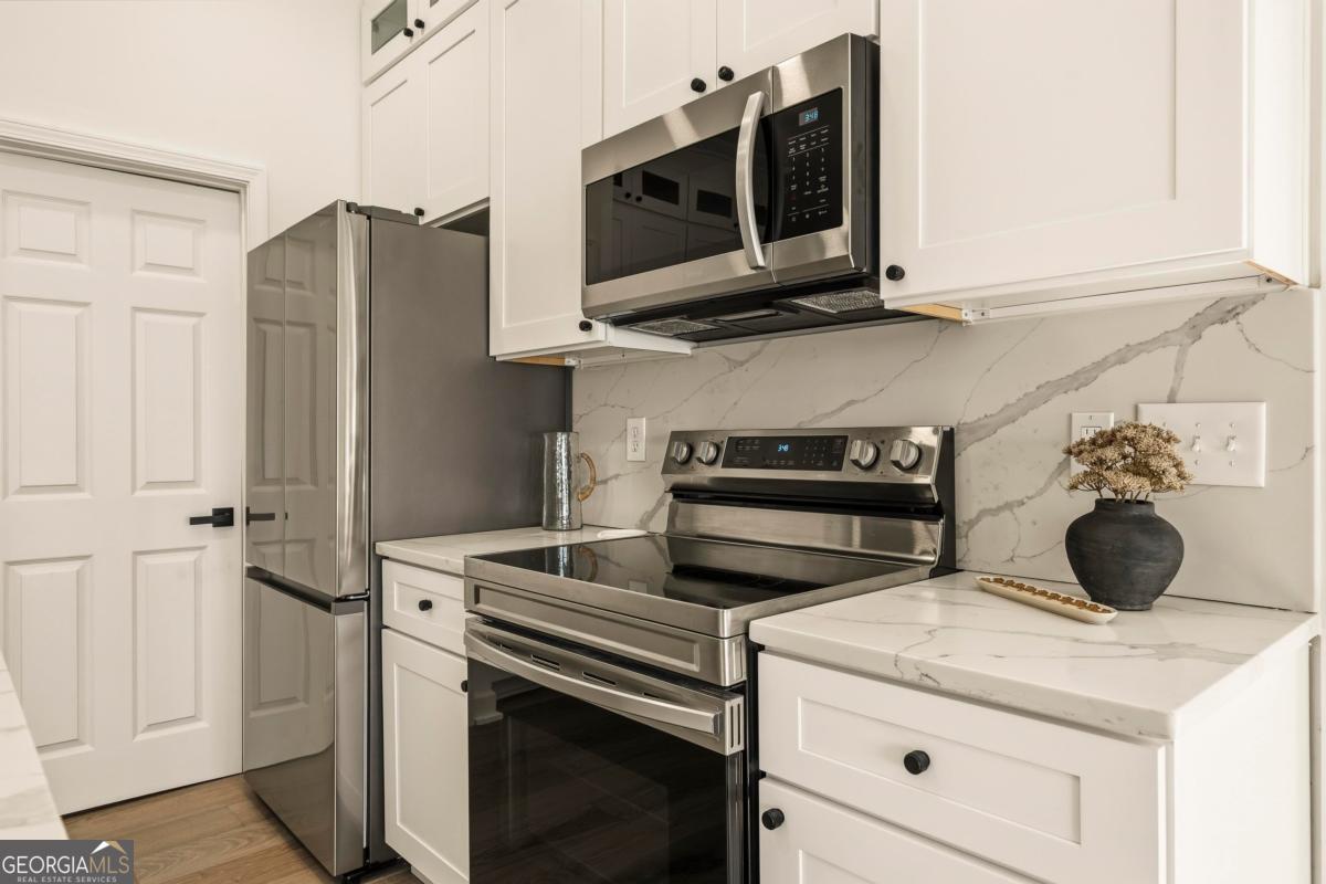 121 Mags Path Eatonton, GA 31024 - Photo 46 of 74 a kitchen with stainless steel appliances white cabinets and a stove top oven