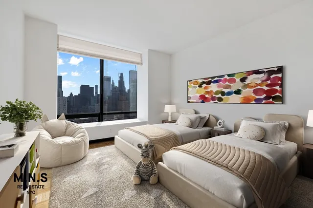 a bedroom with two beds and a large window