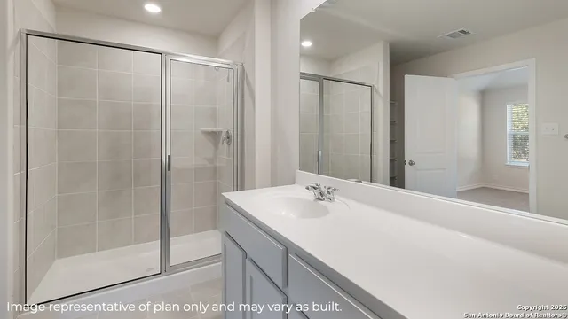 a bathroom with a shower sink and mirror