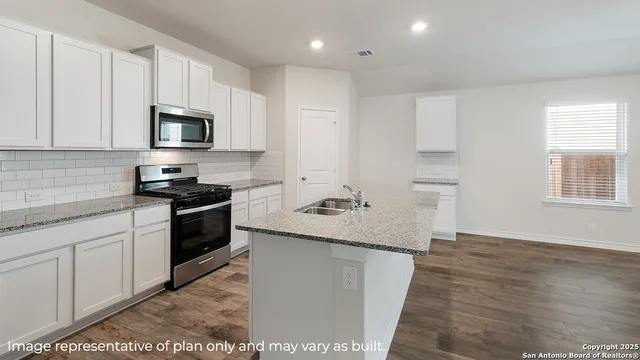 a kitchen with granite countertop a sink and steel appliances