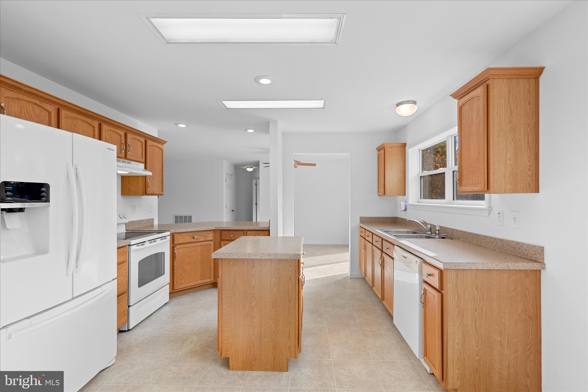 12454 Mirey Branch Road Laurel, DE 19956 - Photo 16 of 51 a kitchen with stainless steel appliances granite countertop a stove top oven a refrigerator a sink and dishwasher with wooden floor