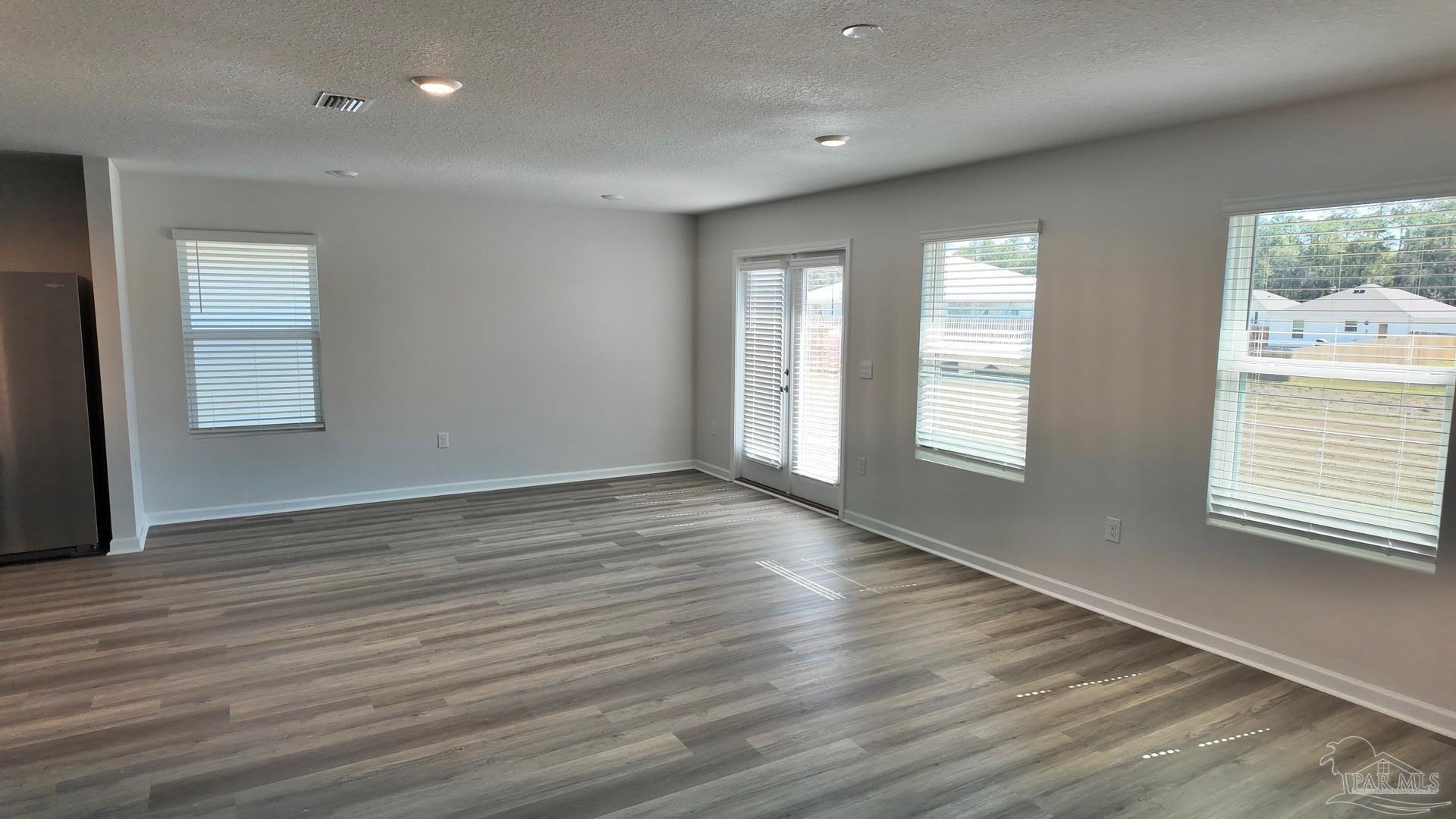 6400 Firefly Drive Milton, FL 32583 - Photo 15 of 41 an empty room with wooden floor and windows