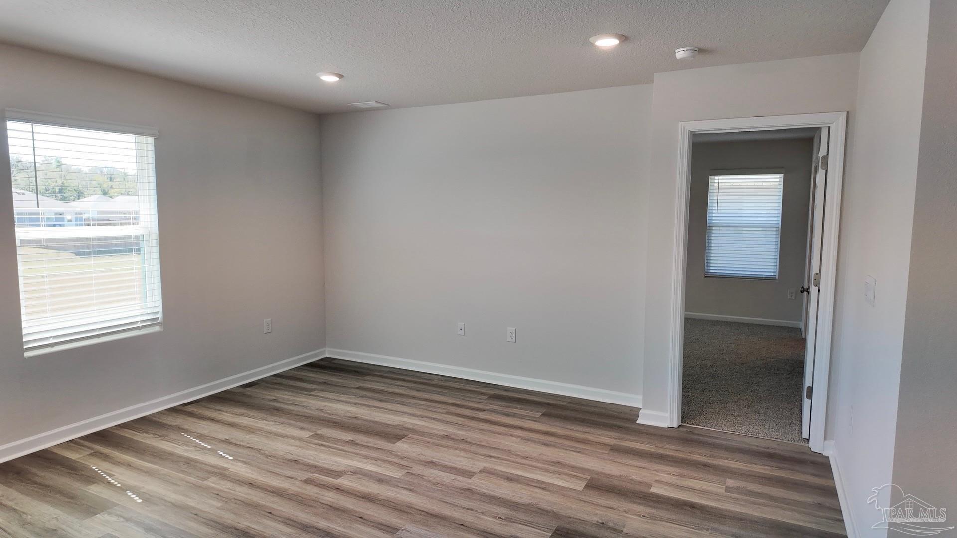 6400 Firefly Drive Milton, FL 32583 - Photo 16 of 41 an empty room with wooden floor and windows