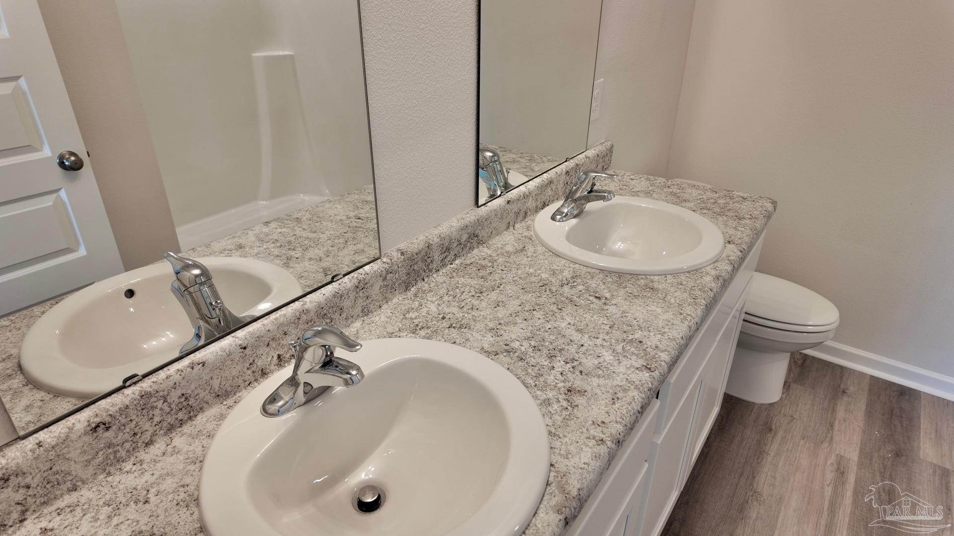 6400 Firefly Drive Milton, FL 32583 - Photo 20 of 41 a bathroom with a granite countertop sink a toilet and a mirror