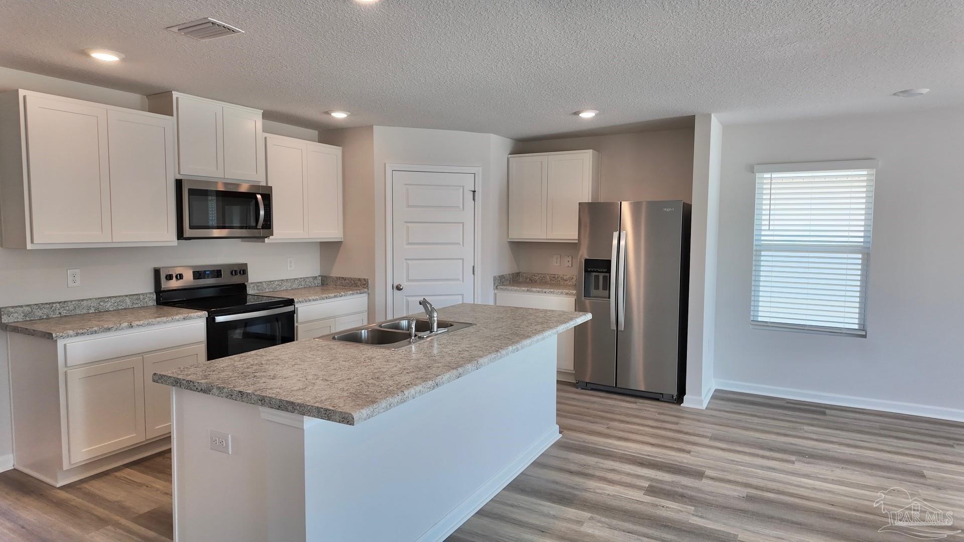 6400 Firefly Drive Milton, FL 32583 - Photo 10 of 41 a kitchen with stainless steel appliances granite countertop a refrigerator a stove a sink and a microwave