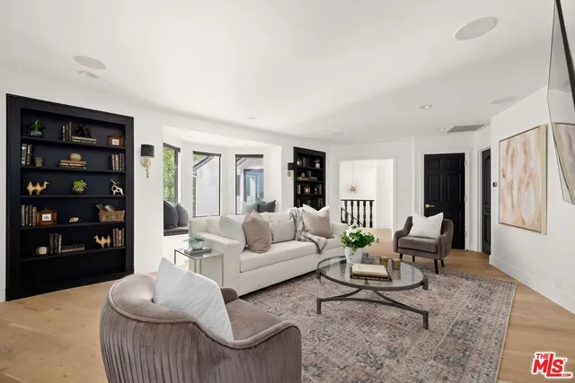 a living room with furniture cabinets and wooden floor
