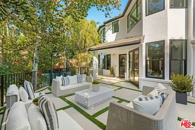 a view of a patio with couches table and chairs and potted plants