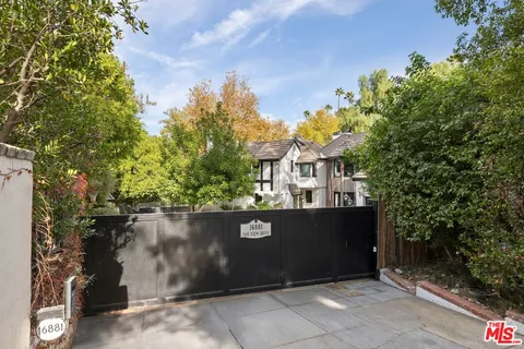 a aerial view of a house with large trees and plants