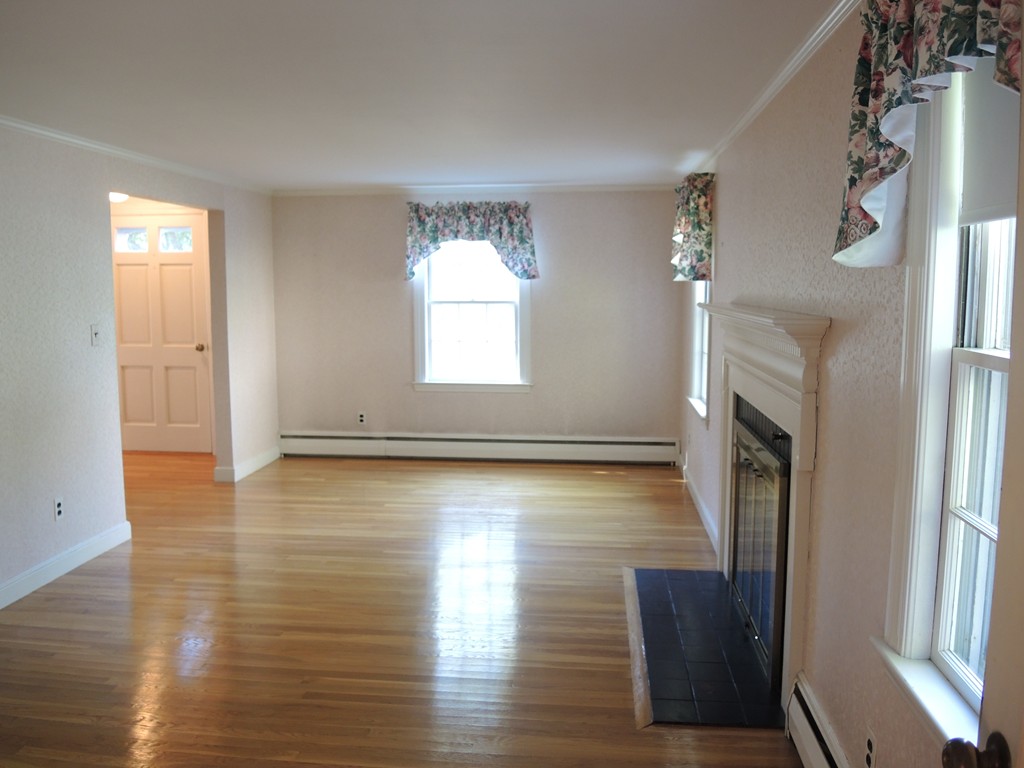 58 Avalon Road Needham, MA 02492 - Photo 10 of 22 an empty room with wooden floor and a fireplace