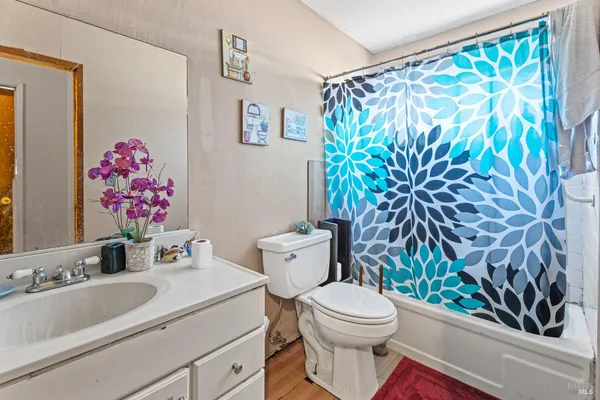 a bathroom with a sink a toilet and a shower curtain