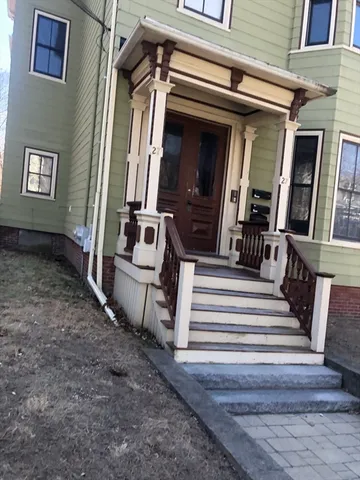a white building covered with snow in front of house