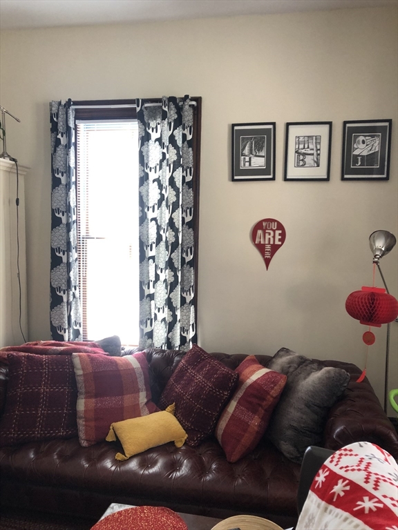 27 Warren Avenue, Unit 1 Somerville, MA 02143 - Photo 6 of 18 a bedroom with a bed and a couch