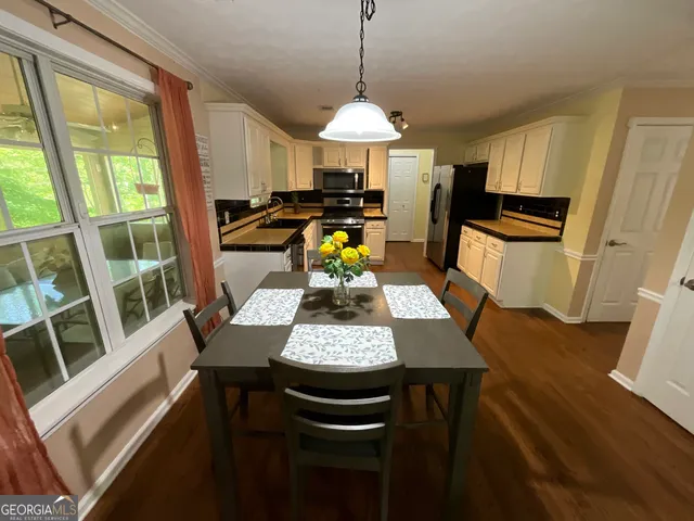 a view of staircase with lots of frames on wall and a window