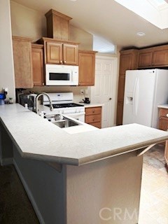 24922 Muirlands Boulevard, Unit 115 Lake Forest, CA 92630 - Photo 3 of 17 a kitchen with kitchen island a sink a stove a refrigerator and cabinets