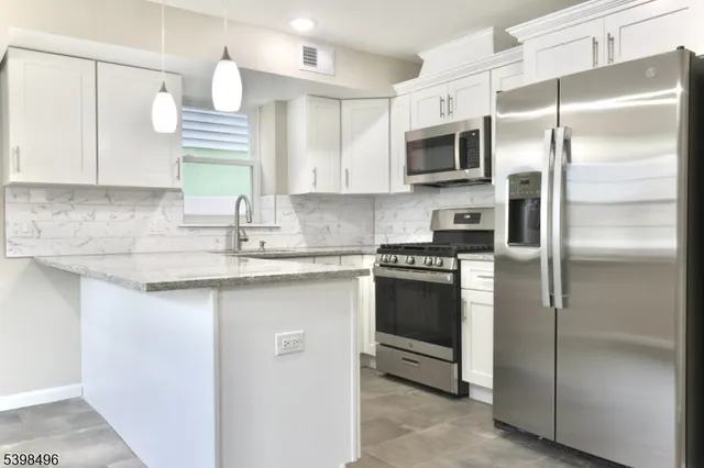a kitchen with stainless steel appliances a refrigerator sink and microwave