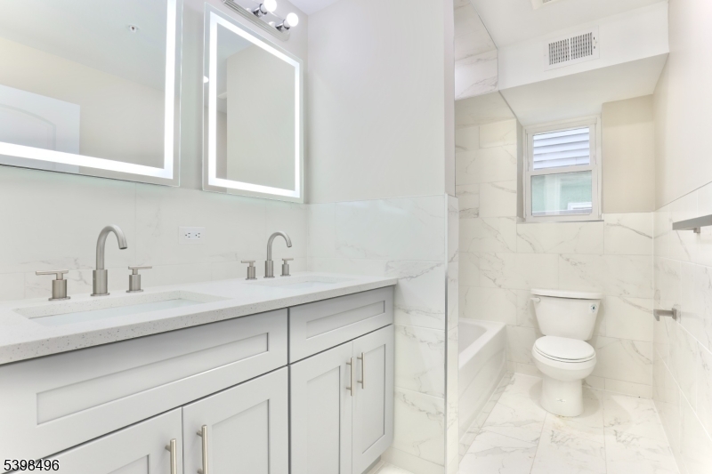 32 Garibaldi Avenue, Unit 1 Newark, NJ 07114 - Photo 6 of 12 a bathroom with a toilet sink and mirror