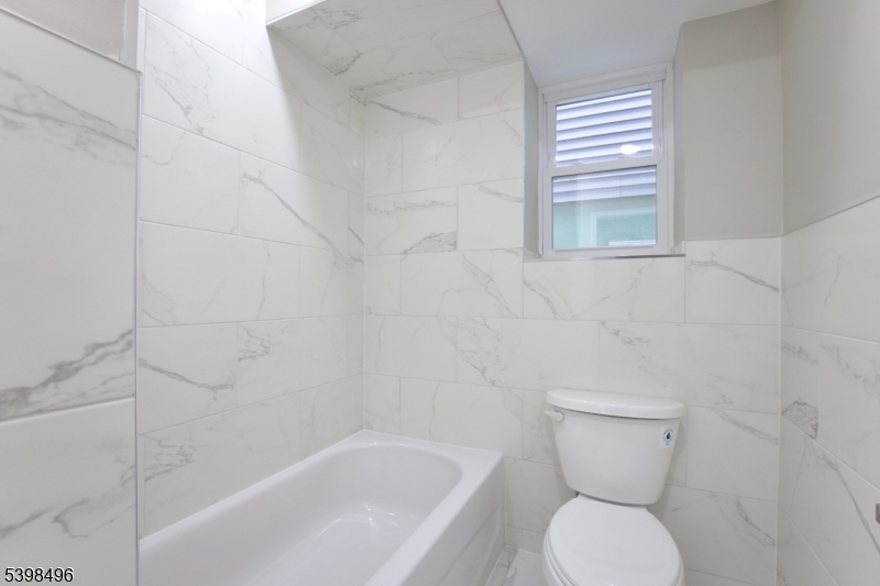 32 Garibaldi Avenue, Unit 1 Newark, NJ 07114 - Photo 7 of 12 a bathroom with a toilet and a bathtub