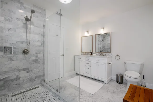 a bathroom with a granite countertop sink toilet and shower