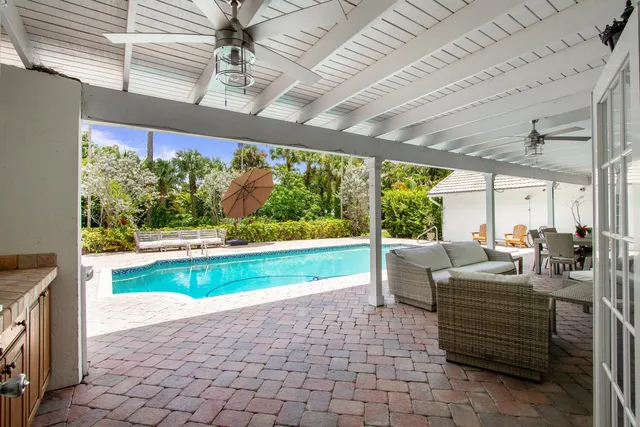 a living room with patio furniture and a floor to ceiling window