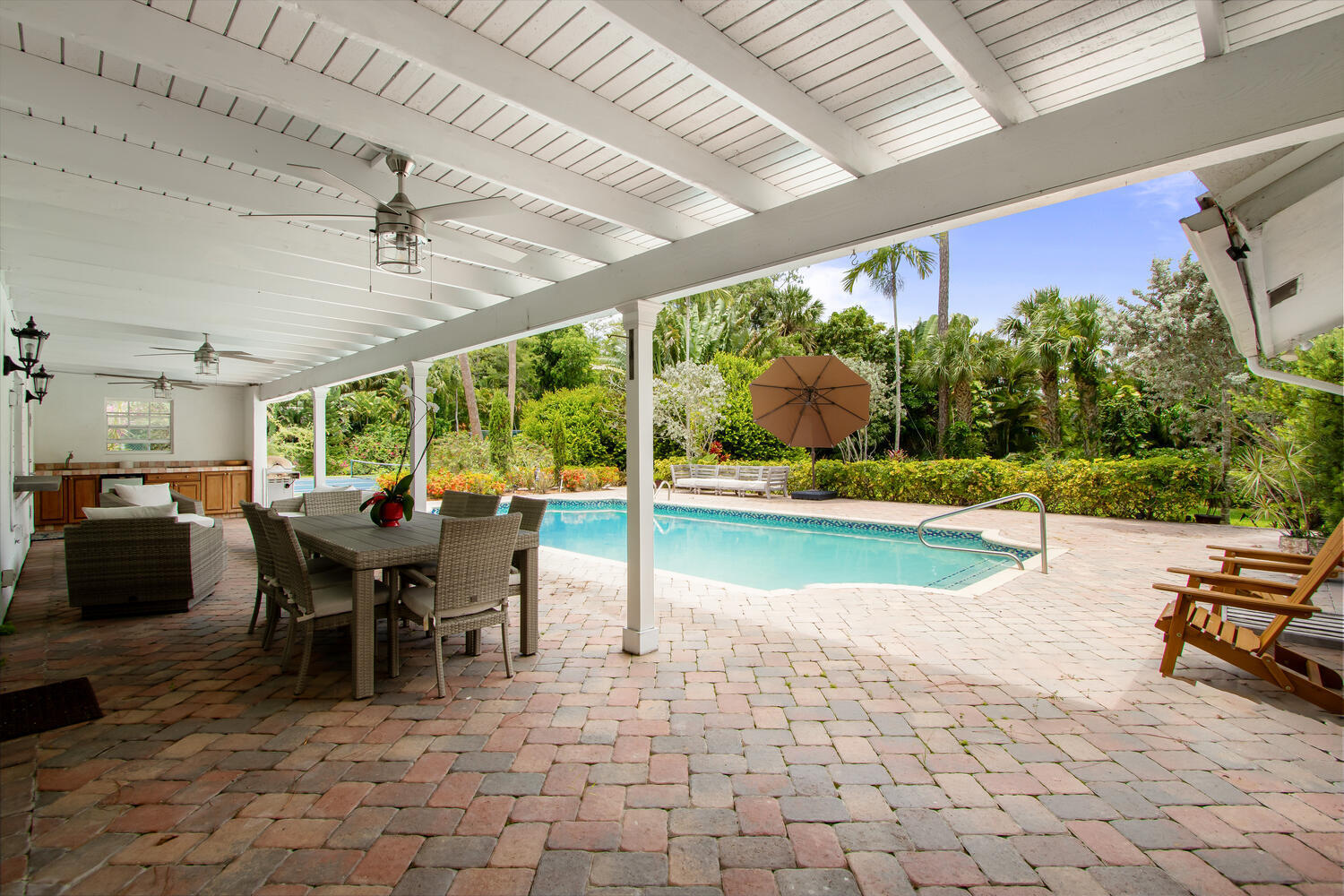 12327 Quercus Lane Wellington, FL 33414 - Photo 21 of 34 a view of a patio with table and chairs potted plants with wooden floor and fence