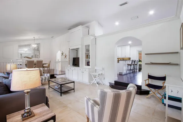 a living room with furniture and a view of kitchen