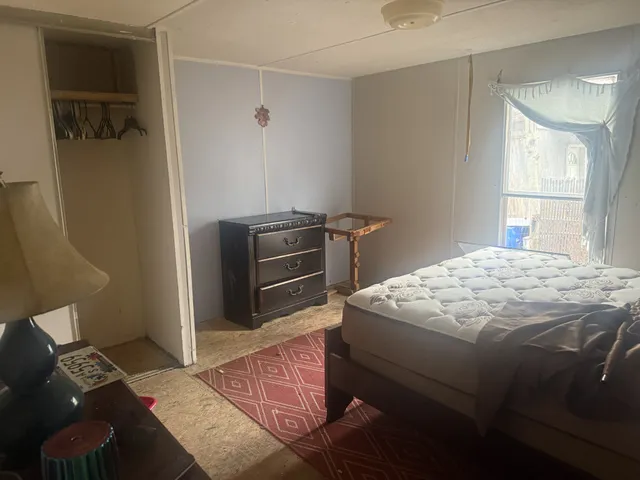 a bedroom with a bed and a window