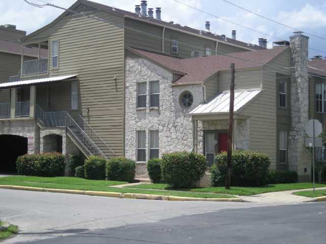 a view of a brick house with a yard next to a road
