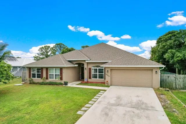 a front view of a house with a garden and yard