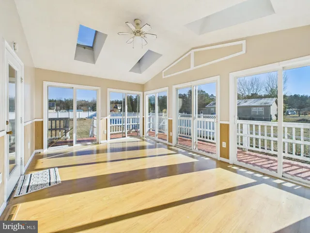 a view of a hall with wooden floor and windows
