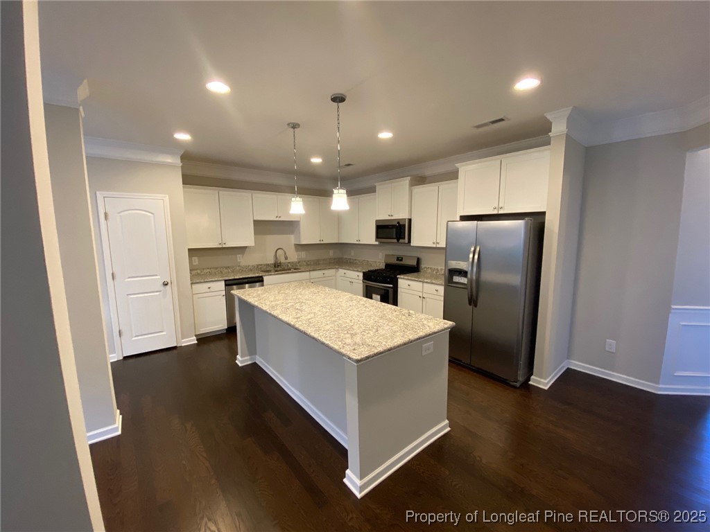 1206 Wingstem Place Cary, NC 27607 - Photo 4 of 26 a kitchen with stainless steel appliances kitchen island granite countertop a refrigerator a sink dishwasher a stove and a oven with wooden floor