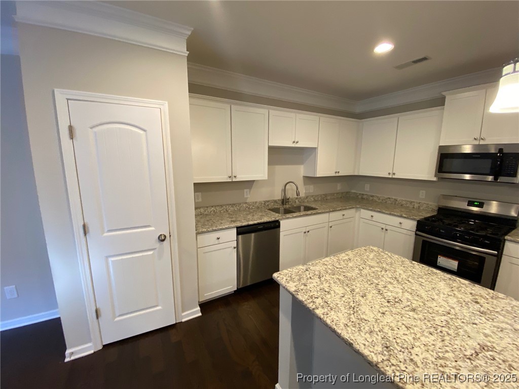 1206 Wingstem Place Cary, NC 27607 - Photo 5 of 26 a kitchen with stainless steel appliances granite countertop a refrigerator sink and stove