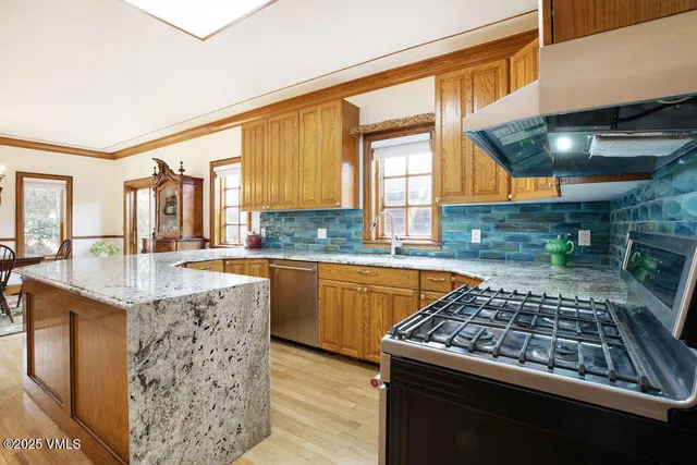 a kitchen with stainless steel appliances granite countertop a stove a sink and a microwave
