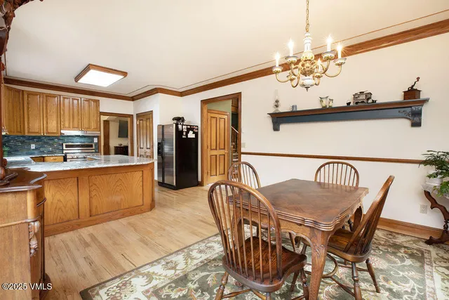 a dining room filled chandelier and wooden floor