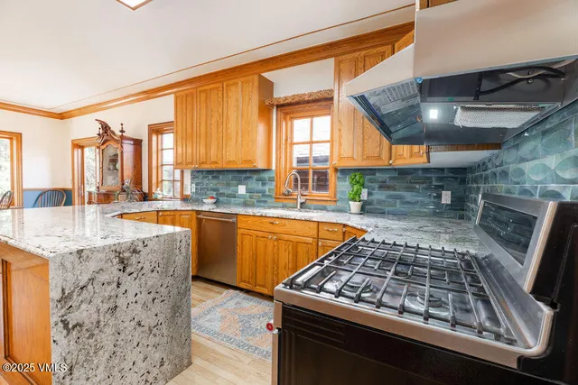 a kitchen with stainless steel appliances granite countertop a sink stove and granite counter tops