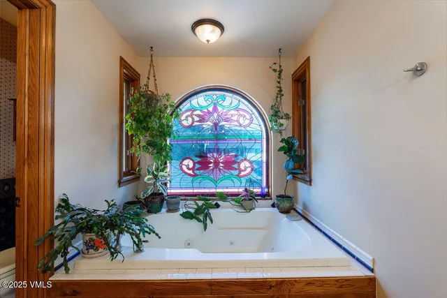 a room with painting on the wall and a potted plant