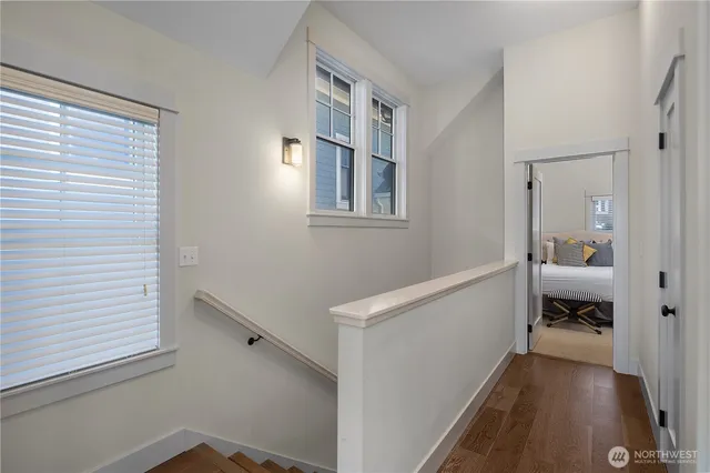 a view of hallway with a window and wooden floor