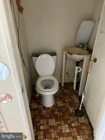 a bathroom with a granite countertop sink a toilet and shower