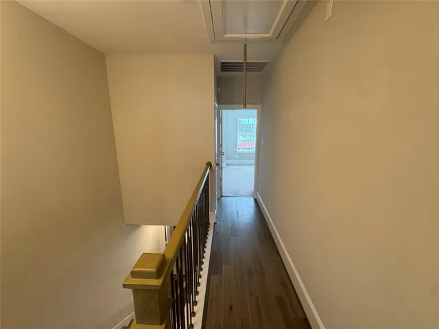 an empty room with chandelier fan and windows