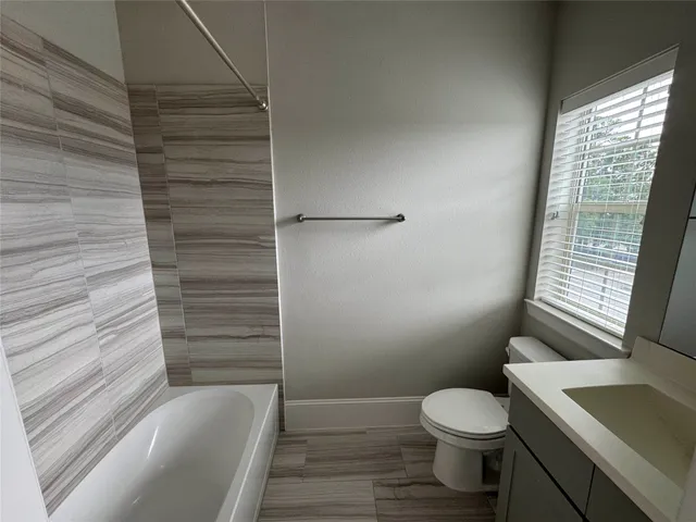 a bathroom with a tub sink and mirror