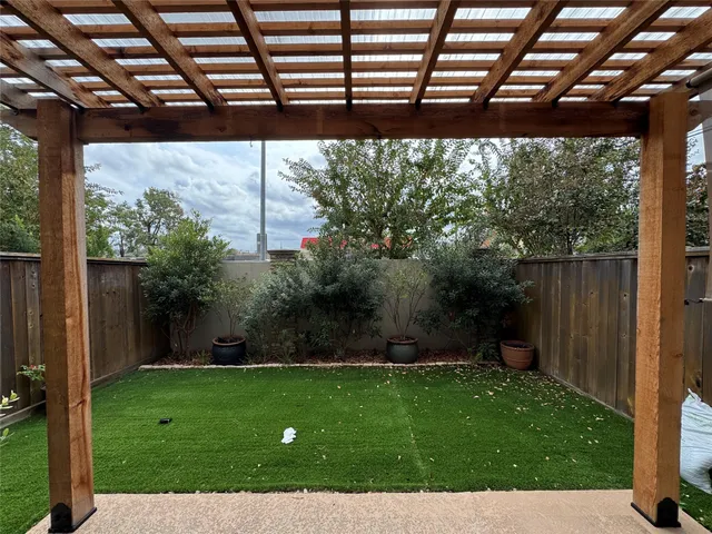 a view of a backyard with potted plants and large trees