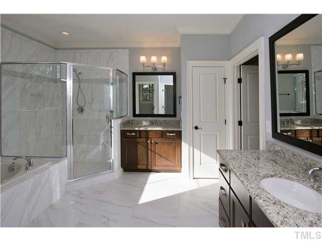 8505 Wynhurst Court, Unit 15 Raleigh, NC 27613 - Photo 17 of 25 a bathroom with a granite countertop sink a toilet a mirror and shower